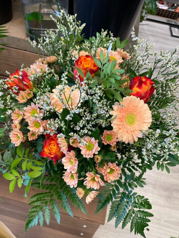 Mother’s Day flower bouquet with peach gerberas, coral chrysanthemums, orange roses, and green foliage – handcrafted by Pleia’s Flowers in Rødovre